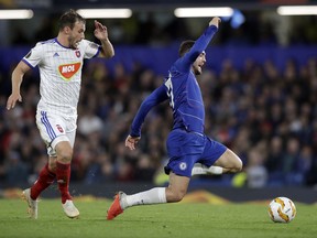 Chelsea's Mateo Kovacic falls down in front of Vidi's Szabolcs Huszti, left, during the Europa League group L soccer match between Chelsea and Vidi FC at Stamford Bridge stadium in London, Thursday, Oct. 4, 2018.