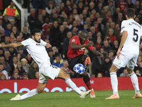 ManU forward Romelu Lukaku attempts a shot at goal between Valencia defender Ezequiel Garay and Valencia defender Gabriel Paulista, right, during the Champions League group H soccer match between Manchester United and Valencia at Old Trafford Stadium in Manchester, England, Tuesday Oct. 2, 2018.