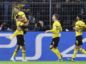 Dortmund defender Raphael Guerreiro, left, celebrates after scoring his side's second goal during the Champions League group A soccer match between Borussia Dortmund and Atletico Madrid at the BVB stadium in Dortmund, Germany, Wednesday, Oct. 24, 2018.