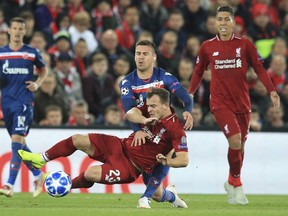 Liverpool midfielder Xherdan Shaqiri, is brought down by Red Star's Marko Marin during the Champions League group C soccer match between Liverpool and Red Star at Anfield stadium in Liverpool, England, Wednesday, Oct. 24,2018.