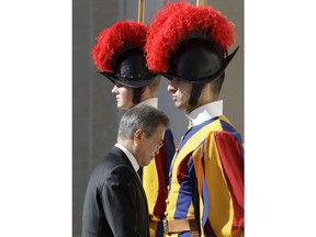 South Korean President Moon Jae-in walks between two Vatican Swiss Guards as he enters the building ahead of his private audience with Pope Francis, at the Vatican, Thursday, Oct. 18, 2018. South Korea's president is in Italy for a series of meetings that will culminate with an audience with Pope Francis at which he's expected to extend an invitation from North Korean leader Kim Jong Un to visit.