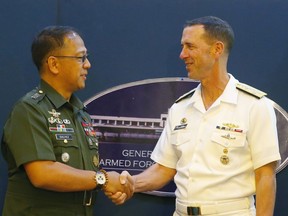 Philippine Armed Forces Chief Gen. Carlito Galvez Jr., left, and Adm. John Richardson, chief of Naval Operations of the U.S. Navy, shake hands prior to a news conference following their meeting Monday, Oct. 29, 2018 at Camp Aguinaldo in suburban Quezon city, northeast of Manila, Philippines. The U.S. Navy will continue patrolling the disputed South China Sea even after a Chinese destroyer came dangerously close to one of its ships during a "freedom of navigation" sail-by near a contested reef.