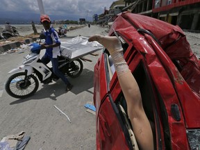 A mannequin leg sticks out from a heavily damaged car at a tsunami-ravaged area in Palu, Central Sulawesi, Indonesia, Tuesday, Oct. 9, 2018. A 7.5 magnitude earthquake rocked Central Sulawesi province on Sept. 28, triggering a tsunami and mudslides that killed a large number of people and displaced tens of thousands of others.