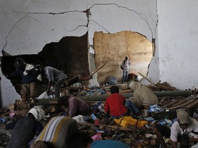 People scavenge for food inside an abandoned warehouse in an earthquake and tsunami-affected area in Palu, Central Sulawesi, Indonesia Indonesia, Wednesday, Oct. 3, 2018. Clambering over the reeking pile of sodden food or staking out a patch of territory, people who had come from devastated neighborhoods and elsewhere in the remote Indonesian city pulled out small cartons of milk, soft drinks, rice, candy and painkillers from the pile as they scavenge for anything edible in the warehouse that tsunami waves had pounded.