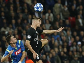 PSG defender Thomas Meunier, right, jumps for the ball with Napoli defender Mario Rui during a Group C Champions League soccer match between Paris Saint Germain and Napoli at the Parc des Princes stadium in Paris, Wednesday Oct. 24, 2018.