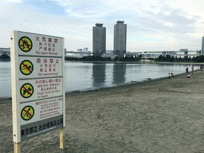 This Oct. 3, 2018, photo, shows a view of the beach at Odaiba Marine Park in Tokyo with a "no swimming" sign displayed. Tokyo 2020 Olympic organizers say a system of layered screens will be used to keep bacteria levels within "agreed limits" for triathlon and marathon swimming in heavily trafficked Tokyo bay.