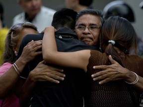 Staff members of jailed councilman Alberto Alban Salazar embrace outside the Bolivarian National Security Service (SEBIN) headquarters in Caracas, Venezuela, Monday, Oct. 8, 2018.