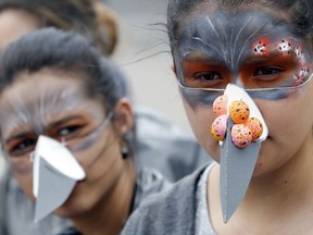 Actors dressed as pigeons perform at Bolivar Square in Bogota, Colombia, Tuesday, Oct. 2, 2018. They urged pedestrians not to feed the large flocks of pigeons that descend each day as part of the city government's fight to control pigeon overpopulation through educational campaigns that urge people not to feed them.