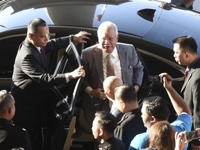 Former Malaysian Prime Minister Najib Razak gets off a car upon arrival at Kuala Lumpur High Court in Kuala Lumpur, Malaysia, Thursday, Oct. 25, 2018. Najib, along with two former high-ranking officials, faces fresh charges of criminal breach of trust involving the use of government funds.