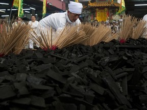 A Malaysian ethnic Chinese man places joss sticks to make fire on the final day of the Nine Emperor Gods Festival at a temple in Ampang, Malaysia, Wednesday, Oct. 17, 2018. The Nine Emperor Gods Festival is an annual Taoist celebration held from the first day to the ninth day of the lunar month. White-clad worshippers lit candles and offered sacrifices to their deities. The nine-day festival has been practiced for many generations by ethnic Chinese in this country.
