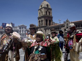 Aymara priests carry out a ritual of burning offerings in honor of mother earth, known as the "Pachamama," the day before the International Court of Justice in The Hague rules on Bolivia's demand for Chile to enter into talks regarding granting the landlocked country access to the Pacific Ocean, outside the Basilica of San Francisco in La Paz, Bolivia, Sunday, Sept. 30, 2018. Bolivia lost its only seacoast to neighboring Chile during a war from 1879 to 1883 and the nation has demanded ocean access for generations.