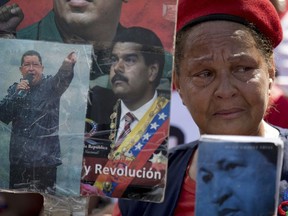 FILE - In this March 15, 2018 file photo, a supporter of Venezuela's late President Hugo Chavez and current President Nicolas Maduro attends a rally marking the fifth anniversary of Chavez's death, in Caracas, Venezuela. A Harvard-trained conflict resolution expert is flying to Caracas to attempt the seemingly impossible: jumpstarting political dialogue in deeply polarized Venezuela.