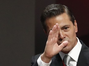 FILE - In this Sept. 3, 2018 file photo, Mexican President Enrique Pena Nieto waves to guests as he arrives to deliver his sixth and final State of the Nation address at the National Palace in Mexico City.  The Pena Nieto adminsitration is looking to protect itself from future investigation of corruption once it leaves power.