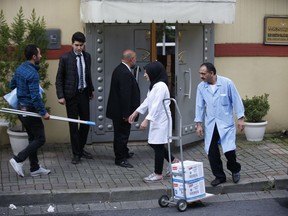 Cleaning personnel wait to enter Saudi Arabia's Consulate in Istanbul, Monday, Oct. 15, 2018. Turkey says an "inspection" of the consulate is expected to take place later on Monday, nearly two weeks after Saudi journalist after Jamal Khashoggi disappeared there.