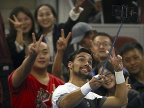 Fabio Fognini of Italy poses for a selfie with fans after beating Andrey Rublev of Russia in their second round men's singles match in the China Open at the National Tennis Stadium in Beijing, Thursday, Oct. 4, 2018.