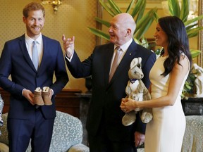 Meghan, right, Duchess of Sussex, reacts as she and Prince Harry, left, receive gifts from Australia's Governor General Sir Peter Cosgrove in Sydney, Australia, Tuesday, Oct. 16, 2018. Prince Harry and his wife Meghan are on a 16-day tour of Australia and the South Pacific.