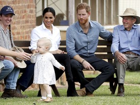 Britain's Prince Harry and Meghan, Duchess of Sussex sit down with the Woodleys family during a farm visit in Dubbo, Australia, Wednesday, Oct. 17, 2018. Prince Harry and his wife Meghan are on day two of their 16-day tour of Australia and the South Pacific.