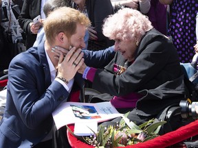 Britain's Prince Harry is embraced by 98-year-old Daphne Dunne during a walkabout outside the Opera House in Sydney, Australia, Tuesday, Oct. 16, 2018. Prince Harry and his wife Meghan are on a 16-day tour of Australia and the South Pacific