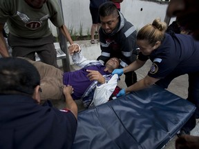 Paramedics attend Honduran migrant Jose Alainez, 49, who suffered an epileptic seizure while walking north with other migrants, before taking him to the hospital in Guatemala City, early Thursday, Oct. 18, 2018. Alainez, traveling alone, had to leave the caravan of more than 2,000 Hondurans trying to wend its way to the United States.