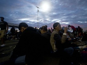 Migrants bound for the U.S.-Mexico border wait on a bridge that stretches over the Suchiate River, connecting Guatemala and Mexico, in Tecun Uman, Guatemala, early Saturday, Oct. 20, 2018.