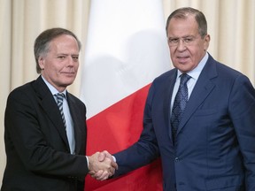 Russian Foreign Minister Sergey Lavrov, and Italian Foreign Minister Enzo Moavero Milanesi shake hands during their meeting in Moscow, Russia, Monday, Oct. 8, 2018.