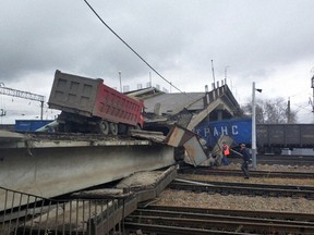 In this photo provided by Amur's region Russian Emergency Situations Ministry, a truck is seen on a road bridge that collapsed on the Trans-Siberian Railway line, in Svobodny, Far Eastern Amur Region, about 5500 km (3417 miles) East from Moscow, Russia, Tuesday, Oct. 9, 2018. According to the Emergency Ministry the driver suffered a broken leg and chest wounds. (Amur's region Russian Ministry for Emergency Situations photo via AP)