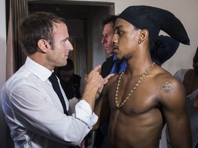 In this photo taken Saturday Sept. 29, 2018, French president Emmanuel Macron meets a former robber of Quartier Orleans, on the French Caribbean island of Saint-Martin, during a trip in the French West Indies, one year after Hurricanes Irma and Maria damaged the Island. Macron said on Sunday that he met with the ex-robber during an unplanned side trip into a housing project in Saint Martin because "I love each child of the (French) Republic, whatever their mistakes."