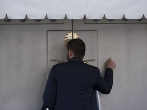 A man knocks the entrance of the Saudi Arabia's consulate in Istanbul, Friday, Oct. 12, 2018. A senior Turkish official says Turkey and Saudi Arabia will form a "joint working group" to look into the disappearance of Saudi writer Jamal Khashoggi.