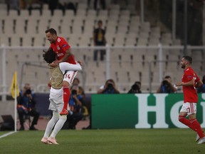 Benfica's Haris Seferovic, jumps as he celebrates with teammates after scoring the opening goal during a Group E Champions League soccer match between AEK Athens and Benfica at the Olympic Stadium in Athens, Tuesday, Oct. 2, 2018.
