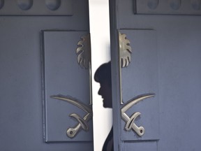 A Consulate staff is seen behind the entrance of the Saudi Arabia's Consulate in Istanbul, Wednesday, Oct. 17, 2018. On Wednesday a pro-government Turkish newspaper published a report made from what they described as an audio recording of Saudi writer and journalist Jamal Khashoggi's alleged torture and slaying at the Saudi Consulate in Istanbul.