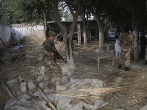 Afghan Security personnel inspect the site of a suicide attack in the Kama district of Nangarhar province, east of Kabul, Afghanistan, Tuesday, Oct. 2, 2018. The suicide bomber struck an election rally on Tuesday, killing at least 13 people and wounding more than 30, a provincial official said. (AP Photo)