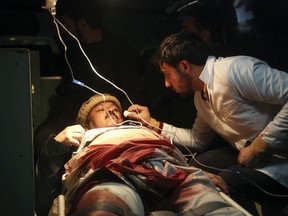 An injured man receives treatment at an ambulance after a suicide attack in Kabul, Afghanistan, Saturday, Oct. 20, 2018.  Police say a suicide bomber blew himself up in front of a polling station in a school in the northern Kabul neighborhood of Khair Khana, the first major attack in Saturday's parliamentary elections.