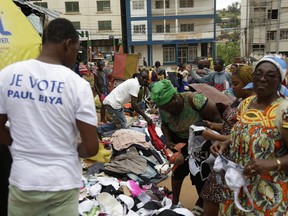 In this photo taken Friday, Oct. 5. 2018, supporters of President Paul Biya buys second hand clothes at the market in Yaounde, Cameroon. Africa's oldest leader is expected to win Sunday's election despite Anglophone separatists threatening to disrupt it.