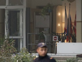 A policeman stands guard near a vocational college in Kerch, Crimea, Thursday, Oct. 18, 2018. An 18-year-old student strode into his vocational school in Crimea, a hoodie covering his blond hair, then pulled out a shotgun and opened fire on Wednesday, killing scores of students and wounding dozens of others before killing himself. (AP Photo)