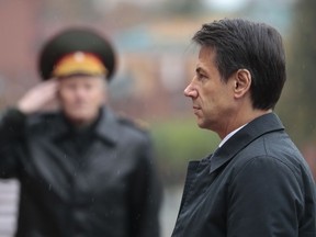 Italian Premier Giuseppe Conte, right, attends a wreath laying ceremony at the Tomb of the Unknown Soldier in Moscow, Russia, Wednesday, Oct. 24, 2018.