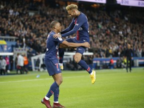 PSG's Kylian Mbappe celebrates with his teammate PSG's Neymar after scoring his side's fourth goal during the French League One soccer match between Paris-Saint-Germain and Lyon at the Parc des Princes stadium in Paris, France, Sunday, Oct. 7, 2018.