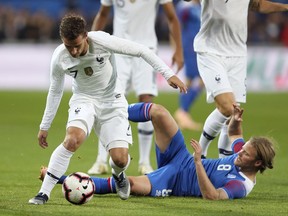 France's Antoine Griezmann, left, and Iceland's Birkir Bjarnason challenge for the ball during a friendly soccer match between France and Iceland, in Guingamp, western France, Thursday, Oct. 11, 2018.