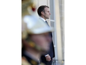 France's President Emmanuel Macron stands as he waits Uzbek President Shavkat Mirziyoyev, prior to a meeting at the Elysee Palace, in Paris, Tuesday, Oct. 9, 2018.