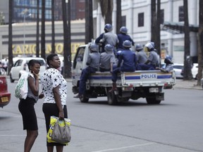 Zimbabwean Riot Police patrol the streets of the capital in Harare, Thursday, Oct, 11, 2018. Lawyers say police in Zimbabwe have arrested dozens of trade union members ahead of a planned protest in the capital over the worst economic crisis in a decade.