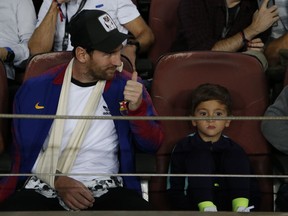 Barcelona forward Lionel Messi sits in the stands prior to the Champions League, Group B soccer match between Barcelona and Inter Milan, at the Nou Camp in Barcelona, Spain, Wednesday, Oct. 24, 2018.