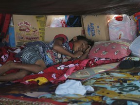 A boy sleeps inside a tent at a temporary shelter in Palu, Central Sulawesi Indonesia, Thursday, Oct. 4, 2018. Life is on hold for thousands living in tents and shelters in the Indonesian city hit by a powerful earthquake and tsunami, unsure when they'll be able to rebuild and spending hours each day often futilely trying to secure necessities such as fuel for generators.