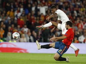 England's Marcus Rashford, background, scores his side's second goal as Spain's Dani Carvajal tries to stop him during the UEFA Nations League soccer match between Spain and England at Benito Villamarin stadium, in Seville, Spain, Monday, Oct. 15, 2018.
