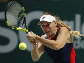 Caroline Wozniacki of Denmark plays a return shot while competing against Petra Kvitova of the Czech Republic during their women's singles match at the WTA tennis finals in Singapore, Tuesday, Oct. 23, 2018.