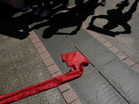 The shadows of protesters are seen next to a red ribbon symbolizes the bottom line of the Chinese Communist Party during a protest in Hong Kong, Saturday, Oct. 6, 2018. The protesters staged a rally against Hong Kong's government has refused to renew the work visa of Victor Mallet, a senior editor of the Financial Times, in what human rights activists say is the latest sign of a deteriorating human rights situation in the semi-autonomous Chinese territory.