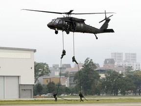 Taiwan's special forces members rappel from a UH-60M Black Hawk helicopter during a military drill in Taoyuan city, Nothern Taiwan, Tuesday, Oct. 9, 2018.