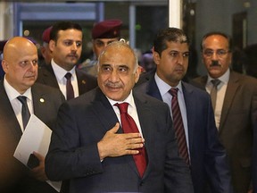 Prime Minister-designate Adel Abdul-Mahdi, center, arrives to the parliament building, in the heavily guarded Green Zone, in Baghdad, Iraq, Wednesday, Oct. 24, 2018.  Iraq's parliament is convening to vote on Prime Minister-designate Adel Abdul-Mahdi's ministry appointments, and the parliament must confirm the appointments for the government to be sworn in.