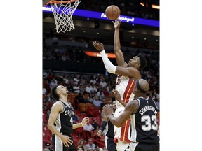 Miami Heat center Hassan Whiteside (21) shoots over San Antonio Spurs guard Derrick White (4) and forward Dante Cunningham (33) during the first half of an NBA basketball game, Wednesday, Nov. 7, 2018, in Miami.