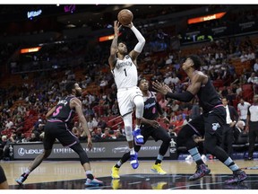 Brooklyn Nets' D'Angelo Russell (1) shoots over Miami Heat's Derrick Jones Jr. (5), Josh Richardson (0) and Hassan Whiteside, right, during the first half of an NBA basketball game, Tuesday, Nov. 20, 2018, in Miami.