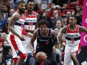 Miami Heat guard Josh Richardson (0) goes after a loose ball against Washington Wizards forward Markieff Morris (5), center Dwight Howard (21) and guard Bradley Beal (3) during the first half of an NBA basketball game Saturday, Nov. 10, 2018, in Miami.