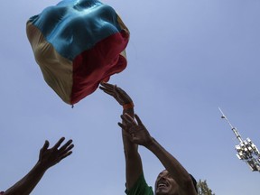 Central American migrant play with other colleagues with a bucket of fabrics at the Jesus Martinez stadium in Mexico City, Wednesday, Nov. 7, 2018. Central American migrants on Wednesday continued to straggle in for a rest stop at a Mexico City stadium, where about 4,500 continue to weigh offers to stay in Mexico against the desire of many to reach the U.S. border.